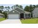 Charming one-story home features a landscaped yard, gray siding, and a two-car garage at 733 Doonbeg Ct., Conway, SC 29526