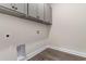 Bright laundry area with grey cabinets, wood-look floors, and utility connections at 733 Doonbeg Ct., Conway, SC 29526