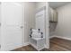 A mudroom area with LVP floors, bench seating, and a glimpse into the laundry area at 733 Doonbeg Ct., Conway, SC 29526