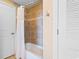 Bathroom with tile shower, white shower curtain, tiled walls and white door at 8121 Amalfi Pl. # 4-1006, Myrtle Beach, SC 29572