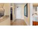 Hallway view to the unit entry and kitchen with tile flooring and neutral decor at 8121 Amalfi Pl. # 4-1006, Myrtle Beach, SC 29572