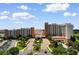Stunning hotel exterior with lush landscaping, fountain, grand entrance, and ample parking on a sunny day at 8121 Amalfi Pl. # 4-1006, Myrtle Beach, SC 29572