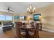 Open-concept living room with a dining table, chandelier, and sliding glass doors to a balcony at 8121 Amalfi Pl. # 4-1006, Myrtle Beach, SC 29572