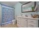 Bathroom featuring a vanity with ample storage and a mirror, complemented by a blue patterned shower curtain at 830 44Th Ave. N # T3, Myrtle Beach, SC 29577