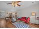 Bright living room with a red sofa, hardwood floors, and a ceiling fan for a cozy and inviting atmosphere at 830 44Th Ave. N # T3, Myrtle Beach, SC 29577