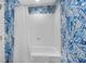 Bright bathroom with blue and white patterned walls and bathtub/shower combo at 8500 Margate Circle # 505, Myrtle Beach, SC 29572