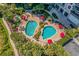 Aerial view showcasing a pool area with vibrant landscaping, red umbrellas, and abundant lounge chairs at 8500 Margate Circle # 505, Myrtle Beach, SC 29572
