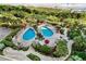 Aerial view of a resort-style pool area featuring multiple pools, lush landscaping, and beach access at 8500 Margate Circle # 505, Myrtle Beach, SC 29572