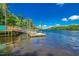 Picturesque boat dock extending into the tranquil waterway with lush vegetation on the bank beneath a blue sky at 904 Moultrie Circle, Myrtle Beach, SC 29588