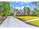 Beautiful exterior of a brick home featuring a long driveway, well-manicured lawn, and mature trees and landscaping at 904 Moultrie Circle, Myrtle Beach, SC 29588