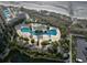 Aerial view of a large community pool with intricate design, surrounded by lush landscaping and seating areas at 9994 Beach Club Dr. # 2402, Myrtle Beach, SC 29572