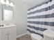 Clean bathroom with a white vanity and a shower with a striped curtain at 1022 Waccamaw Dr., Conway, SC 29526