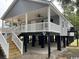 Inviting raised beach house with a covered porch, ceiling fans, and convenient access stairs at 1022 Waccamaw Dr., Conway, SC 29526