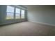 Bright bedroom featuring neutral carpeting, light walls, and a large window with scenic outdoor views at 1117 Oxeye St., North Myrtle Beach, SC 29582
