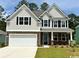 Charming two-story home with stone accents, gray siding, well-maintained lawn, and two-car garage at 135 Stride Ct., Myrtle Beach, SC 29588