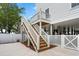 The backyard features a staircase, fenced yard, a concrete patio, and pilings at 135A Sunset Dr., Murrells Inlet, SC 29576