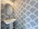 Stylish powder room features leaf-patterned wallpaper, oval mirror, and modern fixtures at 135A Sunset Dr., Murrells Inlet, SC 29576