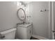 Bathroom featuring a round mirror over a single sink and toilet at 135B Sunset Dr., Murrells Inlet, SC 29576