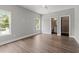 Spacious bedroom with hardwood floors, two windows, ceiling fan, and ensuite bathroom at 135B Sunset Dr., Murrells Inlet, SC 29576