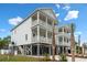 Stunning elevated beach home with dual balconies, covered parking, and well-maintained landscaping at 135B Sunset Dr., Murrells Inlet, SC 29576