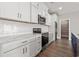Modern white kitchen featuring sleek countertops, stainless steel appliances, and walk-in pantry at 135B Sunset Dr., Murrells Inlet, SC 29576