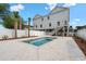 An in-ground pool with a white fence with a home elevated on pilings in the background at 135B Sunset Dr., Murrells Inlet, SC 29576
