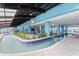 Unique indoor pool with a lazy river design, seating areas, lush greenery, and stylish blue tiling at 1501 S Ocean Blvd. # 1422, Myrtle Beach, SC 29577
