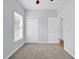 Bedroom featuring neutral carpet, light gray walls, a window with blinds, and double-door closet at 1636 Stuart Square Circle, Myrtle Beach, SC 29577