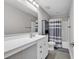 Well-lit bathroom featuring a double sink vanity, a large mirror, and a shower with gray-striped curtains at 1662 Westminster Dr., Myrtle Beach, SC 29577