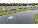Scenic aerial view of homes overlooking a peaceful pond with fountain and green space at 1807 Berkley Village Loop, Myrtle Beach, SC 29579