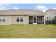 Exterior view of the back of the home, showing the yard and screened patio at 1807 Berkley Village Loop, Myrtle Beach, SC 29579