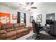 Bedroom featuring dark walls, brown leather reclining sofa, gaming chair, desk, and movie poster decor at 1807 Berkley Village Loop, Myrtle Beach, SC 29579