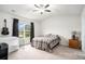 Cozy bedroom featuring a ceiling fan, plush carpeting, and a window view of the backyard at 1807 Berkley Village Loop, Myrtle Beach, SC 29579