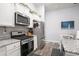 Bright kitchen featuring granite countertops, stainless steel appliances, white cabinetry, and modern fixtures at 1807 Berkley Village Loop, Myrtle Beach, SC 29579