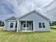 Back exterior view of home with blue siding, white trim, and a covered patio at 181 Norris Ln, Loris, SC 29569