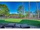 Lush backyard with green grass, mature trees, and a black metal fence overlooking a serene lake at 1903 Francis Ct., Myrtle Beach, SC 29577