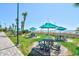 Beach access with picnic tables under green umbrellas on a manicured lawn at 201 74Th Ave. N # 707, Myrtle Beach, SC 29572
