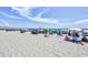 Sandy beach filled with colorful beach umbrellas and happy visitors under a sunny sky at 201 74Th Ave. N # 707, Myrtle Beach, SC 29572