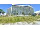 Large beachside hotel rises above the grassy dunes and palm trees at 201 74Th Ave. N # 707, Myrtle Beach, SC 29572