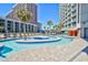 Outdoor lazy river with beautiful blue water, palm trees, lounge chairs, and surrounding hotel at 201 74Th Ave. N # 707, Myrtle Beach, SC 29572