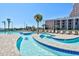 Resort lazy river winds around the pool deck with lounge chairs and palm trees at 201 74Th Ave. N # 707, Myrtle Beach, SC 29572