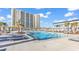Large community pool area surrounded by lounge chairs and palm trees with the community building in the background at 213 Westleton Dr. # 16-D, Myrtle Beach, SC 29572