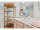 Bathroom featuring a white vanity with a large mirror and decorative wicker shelving unit at 2150 Longwood Lakes Dr. # 2150, Myrtle Beach, SC 29579