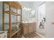 Bright bathroom with a wooden vanity, decorative shelves, and access to another room at 2150 Longwood Lakes Dr. # 2150, Myrtle Beach, SC 29579