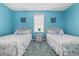Bright bedroom featuring two twin beds, carpet, and light blue walls at 22 Ocean Blvd. N, Surfside Beach, SC 29575