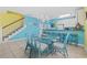 Bright dining area with blue decor, a glass table, and seating for six; adjacent to kitchen with breakfast bar at 22 Ocean Blvd. N, Surfside Beach, SC 29575