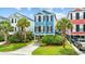 Two-story colorful home with black shutters, palm trees, driveway, and lush landscaping at 22 Ocean Blvd. N, Surfside Beach, SC 29575