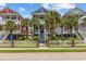 Charming colorful homes with white picket fences, palm trees, and stairs leading to covered porches at 22 Ocean Blvd. N, Surfside Beach, SC 29575