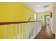 Bright hallway with white railing and wood floors leading to rooms at 22 Ocean Blvd. N, Surfside Beach, SC 29575