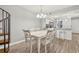 Bright dining area features wood-look flooring, white table with six chairs, and modern chandelier at 223 Maison Dr. # 14D, Myrtle Beach, SC 29572